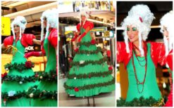 Betoverend kerstentertainment: Kerstboom Lady's Steltenlopers brengen magie met guirlandes en lampjes. Boek nu voor feestelijke sfeer!