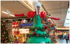 Betoverend kerstentertainment: Kerstboom Lady's Steltenlopers brengen magie met guirlandes en lampjes. Boek nu voor feestelijke sfeer!