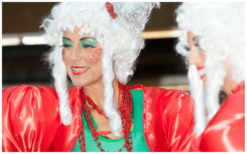 Betoverend kerstentertainment: Kerstboom Lady's Steltenlopers brengen magie met guirlandes en lampjes. Boek nu voor feestelijke sfeer!