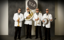 V.I.P. Dixieland Orkest in stijlvolle outfits speelt vrolijke dixielandmuziek tijdens een feestelijk evenement, met een energieke en gezellige sfeer.