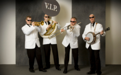 V.I.P. Dixieland Orkest in stijlvolle outfits speelt vrolijke dixielandmuziek tijdens een feestelijk evenement, met een energieke en gezellige sfeer.