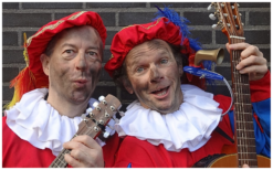 De Bijzondere Muzikale Pieten treden op met vrolijke Sinterklaasliedjes en interactieve dansjes voor een publiek in een winkelcentrum.