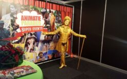 Gouden Welkom Levend Standbeeld boeken voor uw evenement? Luxe ontvangst act in goud kostuum met hoge hoed. Perfect voor beurs, opening, festival of bedrijfsfeest. Mobiel of als standbeeld inzetbaar.