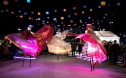 Engel van Licht steltenlopers met grote verlichte vleugels en LED verlichting tijdens een evenement in de avond