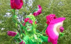 Bloemen Geisha steltenlopers in bloemrijke kostuums tijdens lente thema steltenlopers act op festival of evenement.