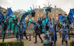 Draken steltenlopers tijdens grote draken parade met fantasie figuren op festival of evenement.