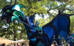 Draken steltenlopers tijdens grote draken parade met fantasie figuren op festival of evenement.