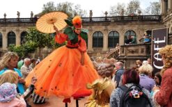 Oranje steltenlopers met grote sinaasappels tijdens een zomers of Koningsdag evenement