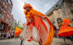 Oranje steltenlopers met grote sinaasappels tijdens een zomers of Koningsdag evenement