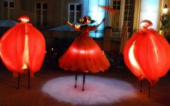 Oranje steltenlopers met grote sinaasappels tijdens een zomers of Koningsdag evenement