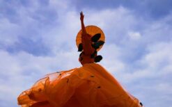 Oranje steltenlopers met grote sinaasappels tijdens een zomers of Koningsdag evenement