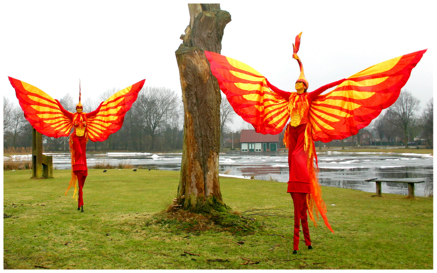 Rood Gele Vuur Vogels Steltenlopers brengen vurige kleuren, hoogte en spektakel naar elk event. Perfect voor festivals, ontvangst en winkelcentra. Een opvallende, energieke act vol warmte en visuele kracht.