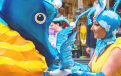 Parade van Neptunus met dolfijnen en zeepaardjes tijdens onderwater thema parade op festival of evenement.