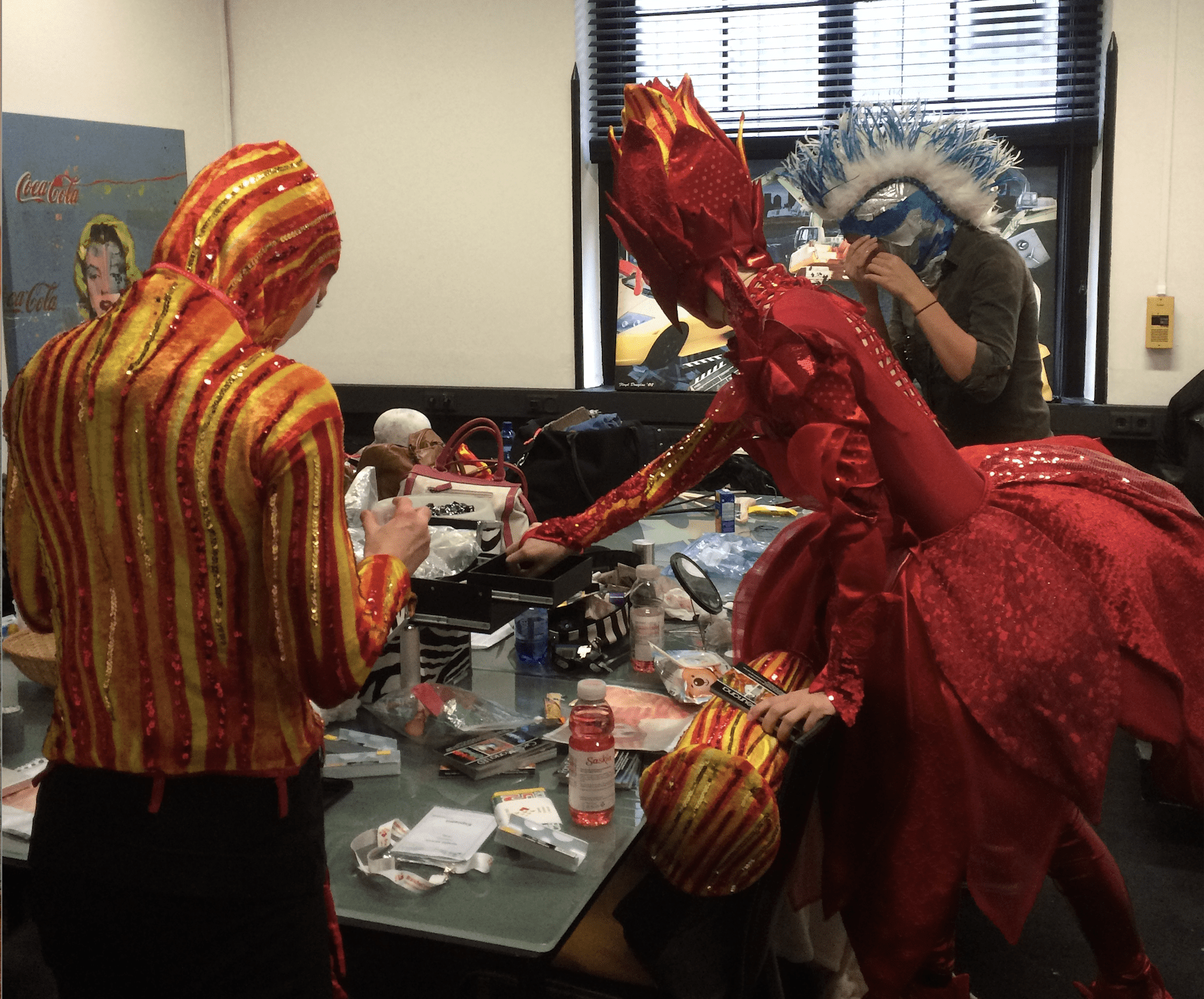 Achter de schermen terwijl een grote groep spelers zich klaarmaakt. Overal is visagie, spelden en haarstukken te zien. De tijd dringt, de performance nadert snel, maar gelukkig is iedereen op tijd klaar