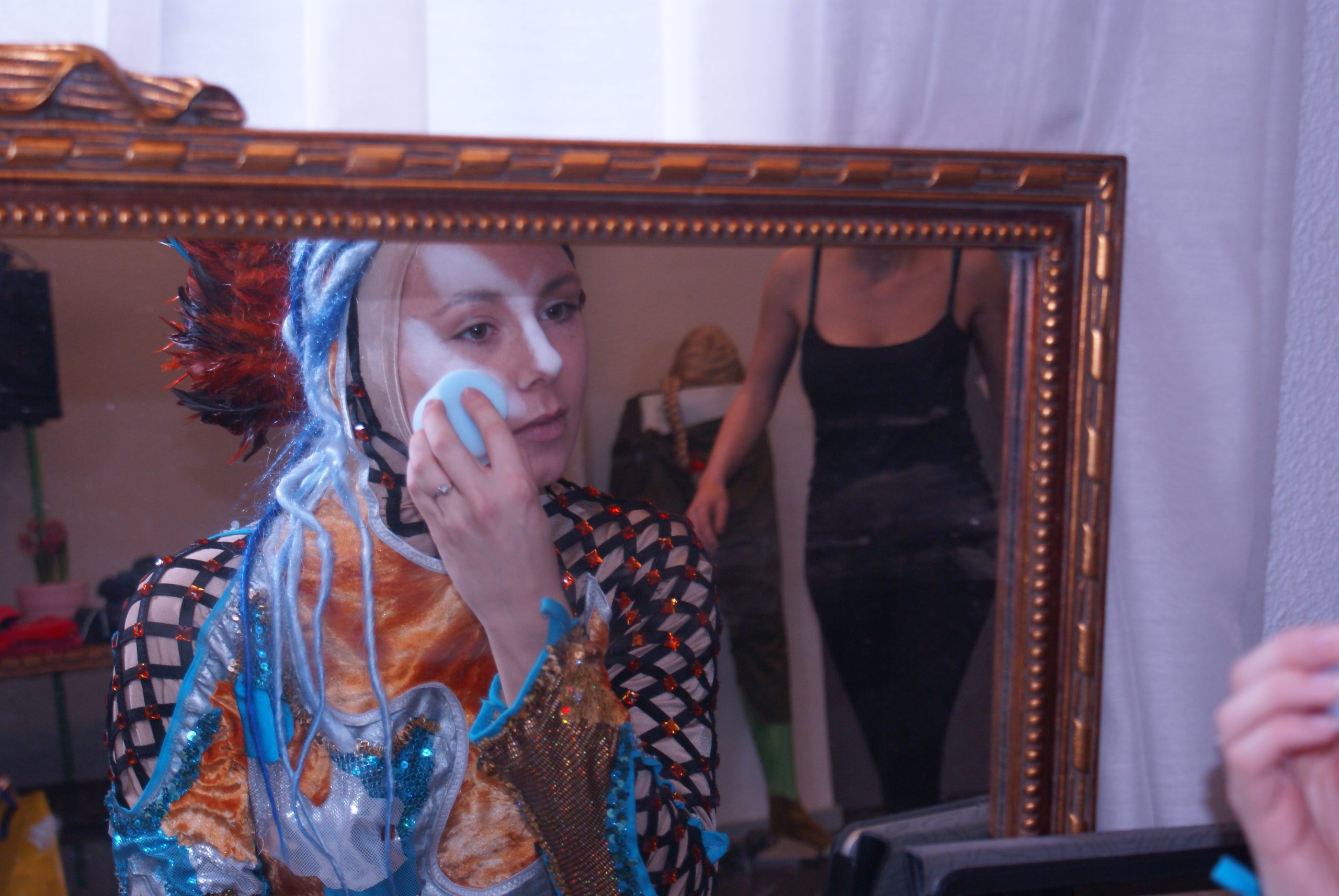 Backstage zie je een van onze top spelers die haar visagie zelf aanbrengt. Dit kostuum vereist een uitdagende visagie die we altijd vooraf oefenen met al onze spelers.