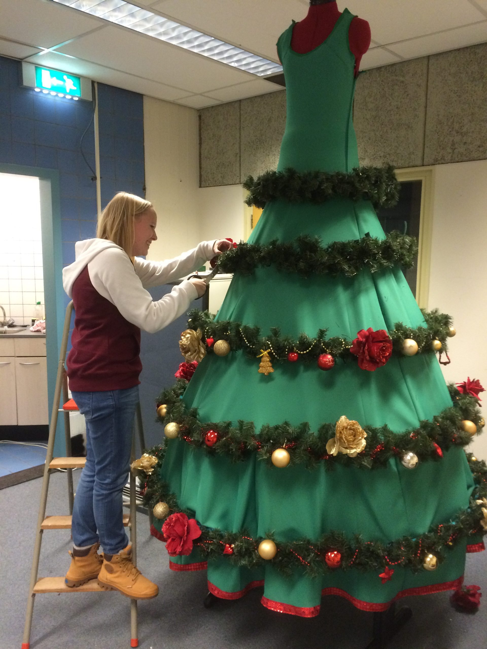 Chantal in actie in het PRIMA Atelier, bezig met het creëren van de betoverende kerstbomen-op-stelten kostuums, elk sprankelend detail met zorg vervaardigend