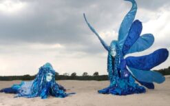 Blauwe winterelfjes steltenlopers tijdens een winterwonderland steltenlopers act op een kerstmarkt of winter evenement.