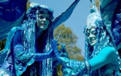 Blauwe winterelfjes steltenlopers tijdens een winterwonderland steltenlopers act op een kerstmarkt of winter evenement.