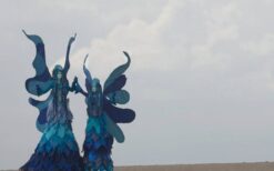 Blauwe winterelfjes steltenlopers tijdens een winterwonderland steltenlopers act op een kerstmarkt of winter evenement.