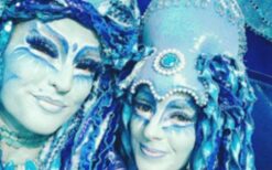 Blauwe winterelfjes steltenlopers tijdens een winterwonderland steltenlopers act op een kerstmarkt of winter evenement.