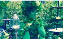 Groene fee animatie act schenkt drankjes aan gasten tijdens ontvangst entertainment op een festival, bruiloft of evenement.