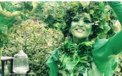 Groene fee animatie act schenkt drankjes aan gasten tijdens ontvangst entertainment op een festival, bruiloft of evenement.