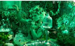 Groene fee animatie act schenkt drankjes aan gasten tijdens ontvangst entertainment op een festival, bruiloft of evenement.