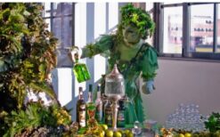 Groene fee animatie act schenkt drankjes aan gasten tijdens ontvangst entertainment op een festival, bruiloft of evenement.