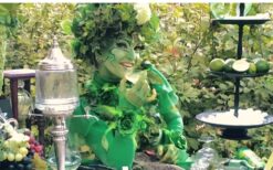 Groene fee animatie act schenkt drankjes aan gasten tijdens ontvangst entertainment op een festival, bruiloft of evenement.