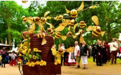 Grote bijen kostuums en dansende bijen tijdens een vrolijke Bijen Parade met duurzame fiets en zwevende bijtjes op een festival of evenement.