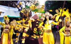 Grote bijen kostuums en dansende bijen tijdens een vrolijke Bijen Parade met duurzame fiets en zwevende bijtjes op een festival of evenement.