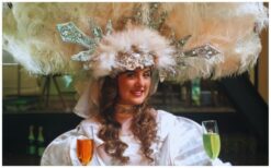 Breng kleur en stijl naar jouw evenement met de Champagne Diva Rood Groen LED! 🥂 Deze opvallende diva rijdt rond met een unieke champagne-rok op wieltjes, gevuld met meer dan 100 glazen of hapjes. De rode en groene LED-verlichting zorgt voor extra sfeer, perfect voor avondfeesten en thema-evenementen. Een stijlvolle en originele manier om jouw gasten te verrassen! Of het nu een bruiloft, kerstfeest, beurs of gala is, deze act past overal bij. De Champagne Diva combineert elegantie met een speelse twist en maakt elk event speciaal. Boek nu en geef jouw feest een extra sprankelende touch!