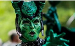 Groene fantasie wezens en steltenlopers tijdens een mysterieuze parade act met natuur en alien thema op een festival of evenement.