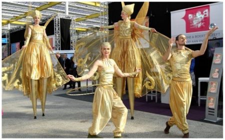 Stap in de magische wereld van “Schoonheid in Goud”! ✨ Een spectaculaire combinatie van steltendans, luchtacrobatiek, hoopdance en contactjuggling betovert het publiek. Deze unieke act schittert als openingsshow, trekt de aandacht op beurzen en evenementen, en brengt straattheaterfestivals tot leven. Een visueel spektakel vol elegantie, kracht en magie! Of het nu op het podium is of tussen het publiek, “Schoonheid in Goud” creëert een onvergetelijke beleving. Met live muzikale begeleiding van harp of percussie wordt de ervaring nog intenser. Laat uw evenement stralen en boek deze betoverende act!