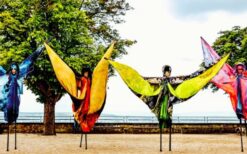 teltenlopers in grote kostuums als aarde, vuur, water en lucht tijdens een parade
