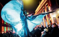 teltenlopers in grote kostuums als aarde, vuur, water en lucht tijdens een parade