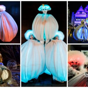 Grote witte sneeuwballen met LED verlichting en performers tijdens een winterse straattheater act