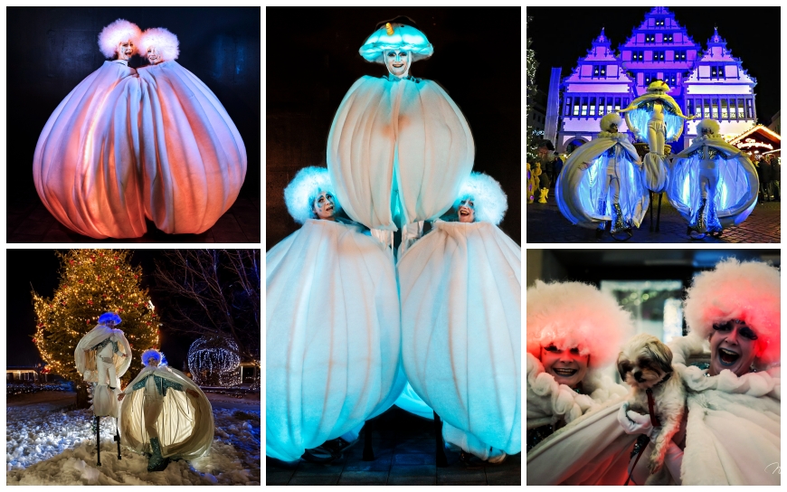 Grote witte sneeuwballen met LED verlichting en performers tijdens een winterse straattheater act