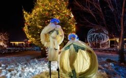 Grote witte sneeuwballen met LED verlichting en performers tijdens een winterse straattheater act