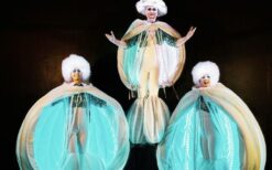 Grote witte sneeuwballen met LED verlichting en performers tijdens een winterse straattheater act