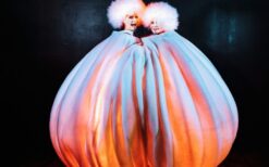 Grote witte sneeuwballen met LED verlichting en performers tijdens een winterse straattheater act