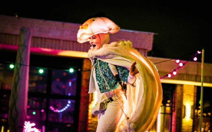 Grote witte sneeuwballen met LED verlichting en performers tijdens een winterse straattheater act