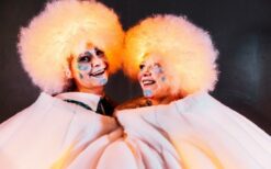 Grote witte sneeuwballen met LED verlichting en performers tijdens een winterse straattheater act